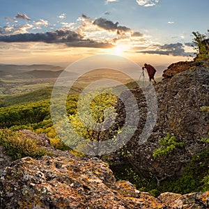 Silouette od photographer in nice mountain sunset with green forest