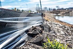 silt fence at a construction site with exposed dirt piled against the fabric