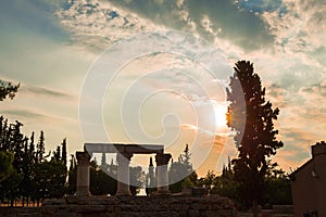 Siluette of anchient ruins of temple in Corinth, The lights of sun brights through. Greece - archaeology background
