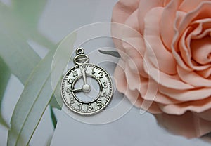 Silver amulet in the form of a clock face on a white background