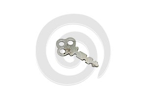 A silver, antique luggage key isolated on a white background