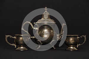Silver antique teapot on a black background. A beautiful antique silver teapot. The kettle is silver.