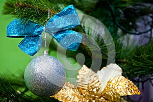 Silver ball decoration with a blue bow for a Christmas tree