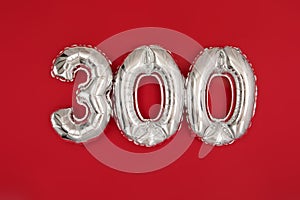 Silver balloon showing number 300 on red background