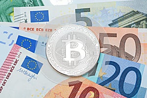 Silver Bitcoin close-up. Background euro currency. Conceptual ph