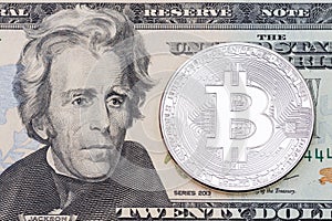Silver bitcoin coin on one dollars banknote close up.