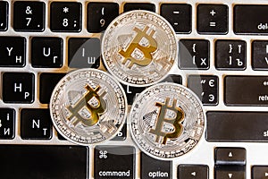 Silver bitcoin coins on the white keyboard. Close up. Bitcoin up. Cryptocurrency