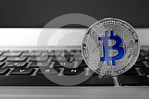 Silver bitcoin on computer keyboard. Digital currency