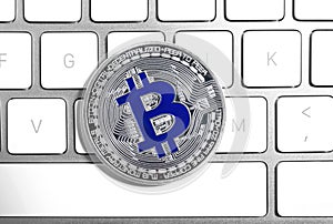 Silver bitcoin on computer keyboard. Digital currency