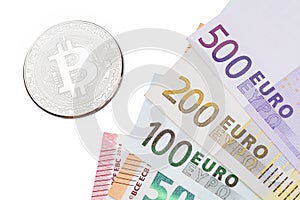 Silver Bitcoins close-up Bitcoin and euros on white background.