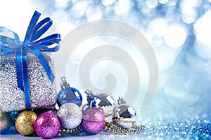 Silver and blue Christmas balls and gifts on blue lighting back