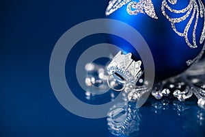 Silver and blue christmas ornaments on dark blue background with space for text. Merry christmas card.