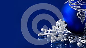 Silver and blue christmas ornaments on dark blue background