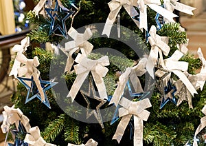 Silver blue star and a white ribbon on a festive Christmas tree, decoration element Christmas