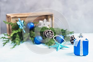 Silver and blue toy gift, christmas toys spill out of wooden box with dreen tree branches