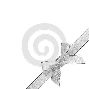 Silver bow with ribbon in the lower right corner. Close up. Isolated on white background