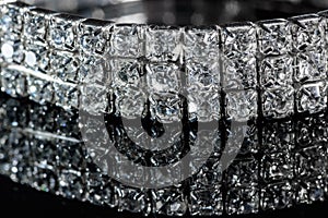 Silver bracelet with diamonds close-up on a black mirror background