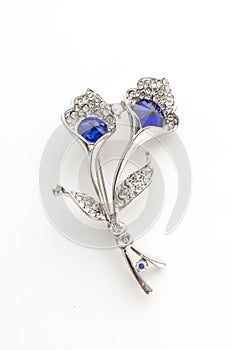 Silver brooch flower with blue stone isolated on white