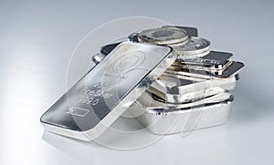 Silver bullion. Cast and minted bars and coins on a gray background. photo