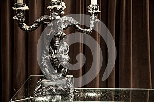 Silver candle holderwith candles lit on a table.