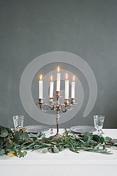 Silver chandelier with burning candles on the table