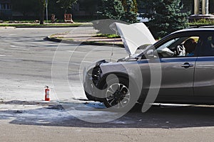 Silver car after a crash with fire.