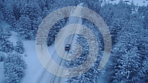 Silver car driving on winter country road in snowy forest