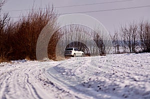 Silver car on the edge of a snowy field