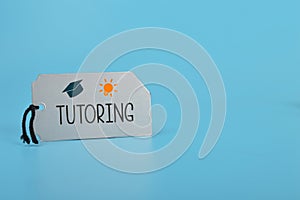 Silver card written with TUTORING. Tutoring provides a personalized and tailored approach to learning, helping students to photo
