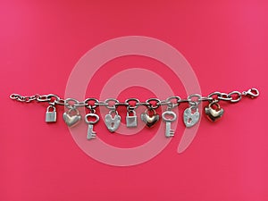 Silver charm bracelet pink background