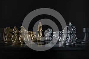 Silver chess knight is facing golden chess king on black background. Business strategy, market share, business competition,