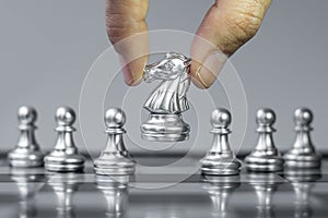 Silver Chess knight figure Stand out from the crowd on Chessboard background. Strategy, leadership, business, teamwork, different