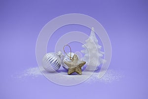 Silver Christmas balls, gold star and white Christmas tree on purple background with copy space. Concept winter card
