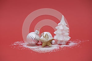 Silver Christmas balls, gold star and white Christmas tree on red background with copy space. Concept winter card