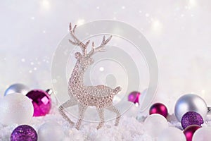 Silver christmas decoration deer and christmas balls on a pink winter background. Christmas holiday mood. Magic and fairy tale