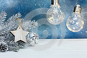 Silver christmas fir tree branch, tree decorations and glowing r