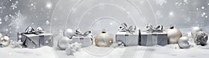 Silver Christmas gifts, balls and decorations in a row on abstract background.