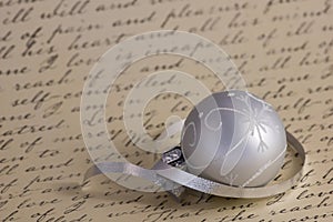 Silver Christmas ornament on calligraphy background