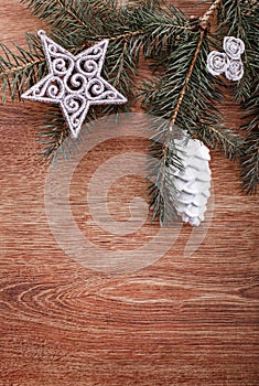 Silver Christmas ornaments and fir tree branch on a rustic wooden background