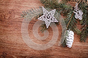 Silver Christmas ornaments and fir tree branch on a rustic wooden background. Xmas card. Happy New Year. Top view