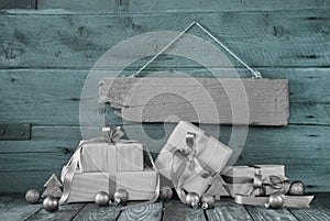 Silver christmas presents on wooden background with a sign.