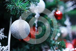 Silver Christmas toy on a fir branch, Christmas background with selective focus