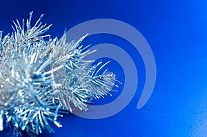 Silver Christmas tree branch on the blue background creative concept