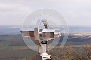Silver Coin Operated binocular viewer with landscape in the background