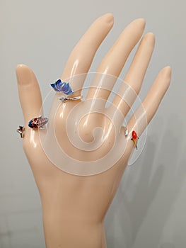 Silver color bijou rings with enamel fish and lotus flower ornament on mannequin hand