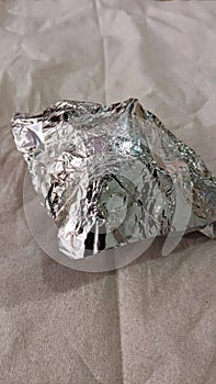 Silver colored aluminum foil on white tissue. photo