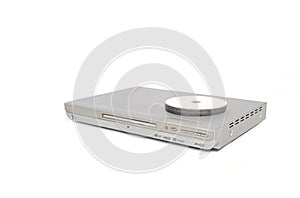 Silver colored dvd or cd player with several discs placed on top.