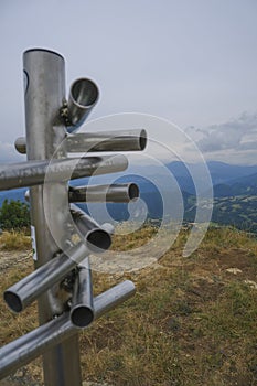 Silver-colored metal signpost in the mountains close-up across aerial mountains view. Adventure, travel lifestyle. Pietra di Bisma