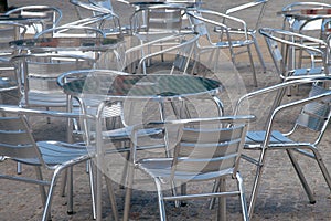 Silver coloured alluminium tables and chairs outside a cafe