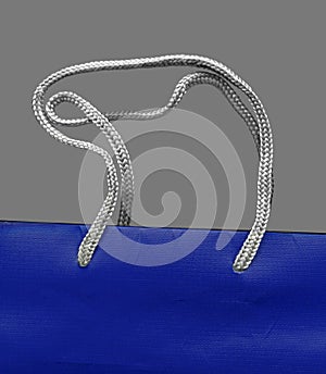 Silver coloured braided cords at a blue bag
